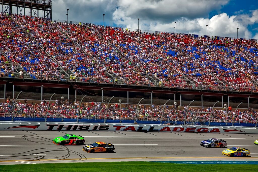 NASCAR team cars racing down the stretch of Talledega Supermotorspeedway in Alabama.